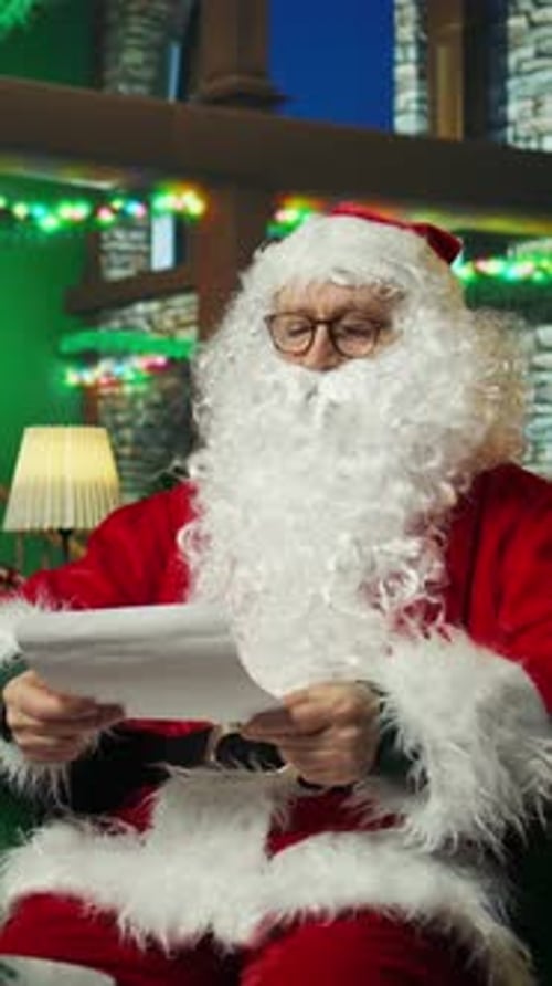 Santa Claus Reading Letter Indoors During Christmas