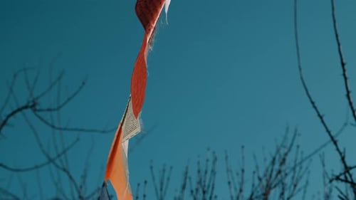 Colorful Tibetan Buddhist prayer flags waving against clear blue sky in Nepal, close-up detail view