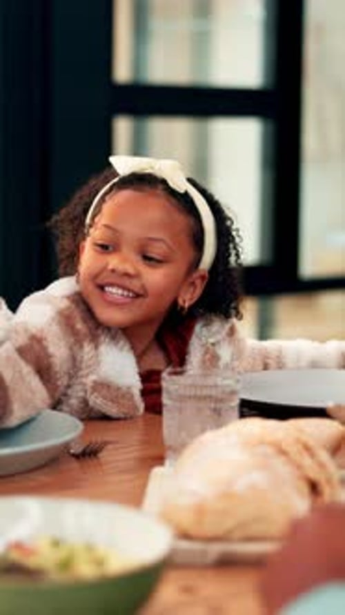 Happy Girl Eating a Small Sandwich at Table