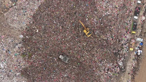 Bulldozer and excavator working in a large garbage landfill aerial view