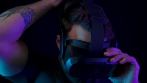 Man Puts on VR Headset in Dark Room