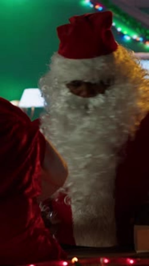 Vertical Video Black Saint Nick Prepares a Gift Box By the Fire in North Pole Workshop