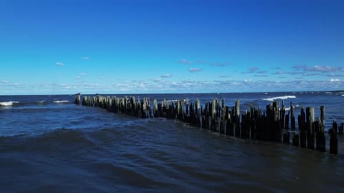 A wooden structure in the ocean with waves coming in