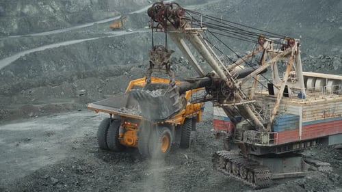 Excavator Loading Dump Truck in Open Pit Mine
