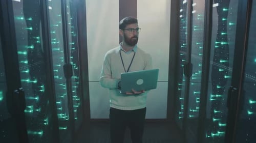 Bearded Man Holds Laptop in Data Center