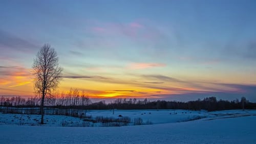Snowy Field at Colorful Sunset in Winter