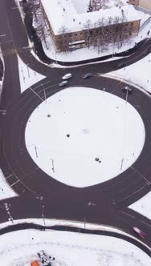 Traffic Circle in the City and Cars on Road at Winter Day Orbiting Aerial View Vertical Video