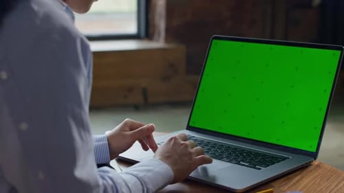 Person Scrolling on Laptop with Green Screen