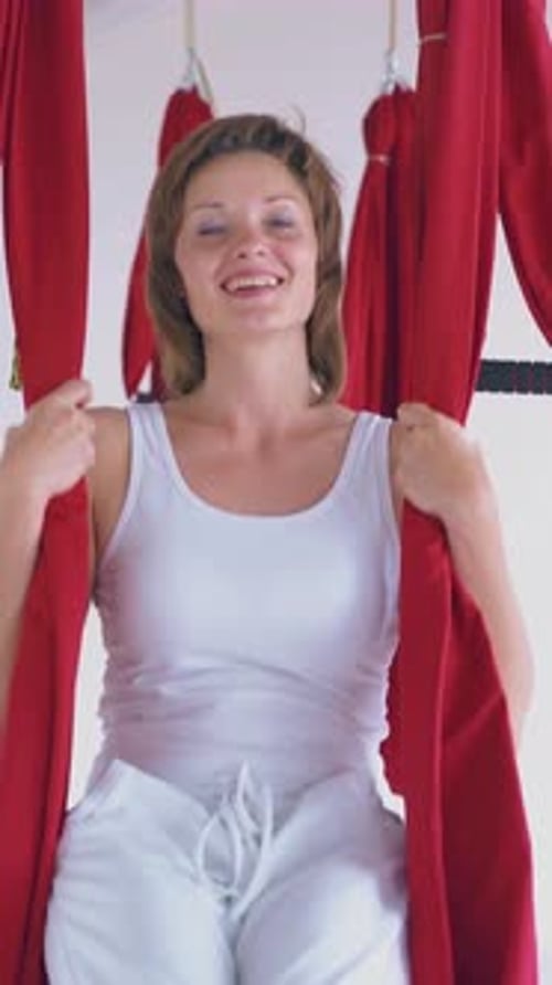 Woman Exercising with Aerial Yoga Hammock in Studio