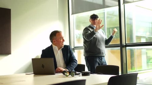 Businessman Showing Innovative Augmented Mixed Reality Goggles to a Client