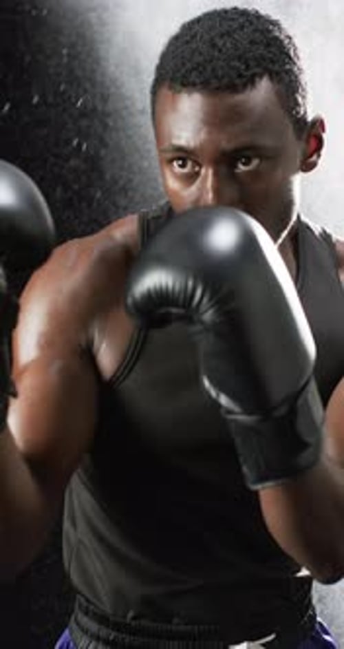 Muscular Boxer Trains in Black Gloves