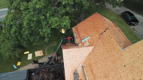 Roofers Installing a New Roof on an Residential Building Aerial Wide Shot