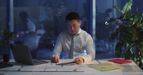 A Focused and Committed Professional Working Late Hours in a Modern Office Environment