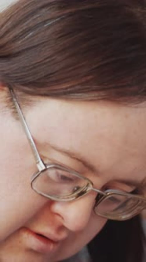 Vertical of Diligent Man with Disability Paper Cutting during Creative Workshop