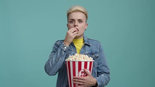 Closeup Shot of Caucasian Woman Eating Fresh Delicious Popcorn in the Cinema