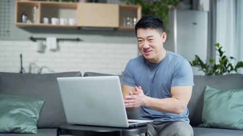 Man Video Conferencing at Home on Laptop