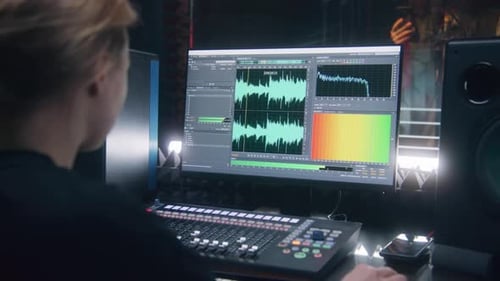 Person Adjusting Audio Mixing Board in Studio