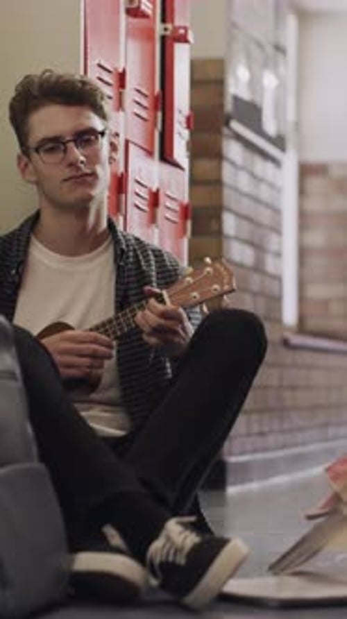 Bullying, education and guitar with male student on floor of university corridor for music study