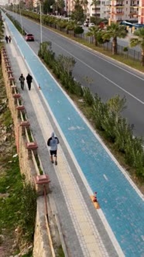 Aerial View of City Jogger on Path by Beach