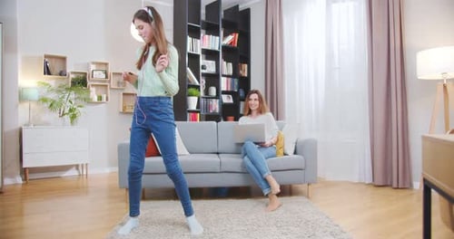 Teenage Girl Dancing to Music in Living Room