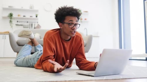 Young Man Video Conferencing at Home on Laptop