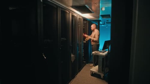 IT Technician Working in Dark Server Room