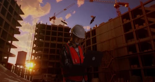 Side View Of Asian Male Engineer Working On A Laptop At Construction Site
