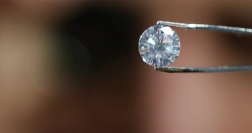 Sparkling Diamond Held by Metal Tweezers