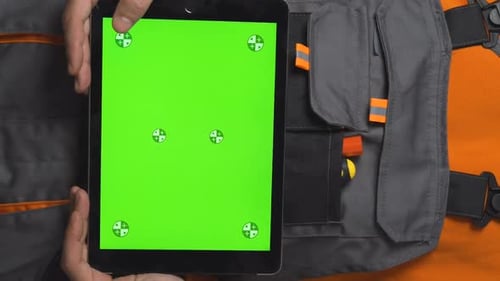 Vertical Video of Close Up Shot of Worker Hands Holding a Tablet with Green Screen