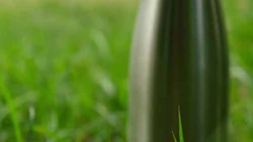 Water Bottle Reusable Steel Thermo Water Bottle on Green Grass Sustainable Lifestyle Plastic Free
