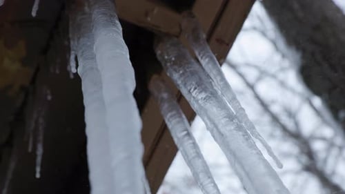 Handheld shot of large icicles hanging off a balcony. Shot in 4k