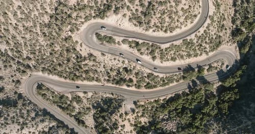 eine kurvenreiche Straße mit Autos, die durch die Wüste fahren