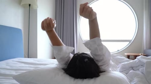 Asian woman waking up and sleep at morning in hotel room travel tourist concept
