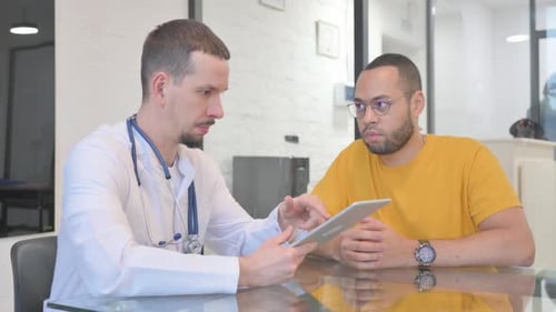Doctor Showing Results on Tablet to Patient