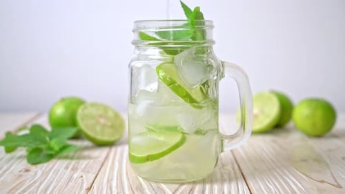 Refreshing Limeade Drink Being Poured into Glass Jar