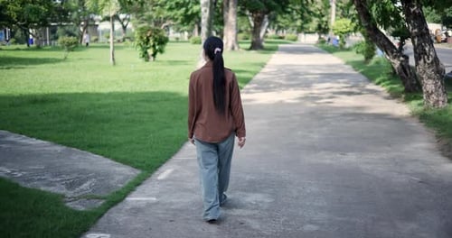 A cheerful young woman takes a walk and enjoys the fresh air and natural scenery.