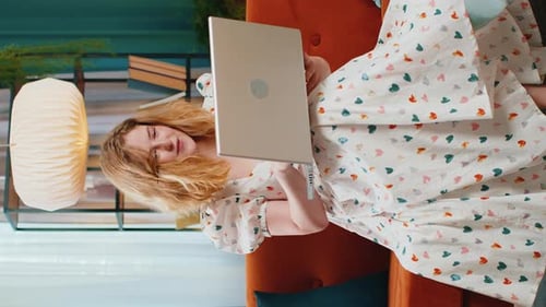 Woman Lies on Sofa Opens Laptop and Smiles