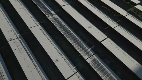 Mit Schnee und Eis bedeckte Sonnenkollektoren eines Solarkraftwerks, teilweise aufgetaut, Drohnenaufnahme im Orbit