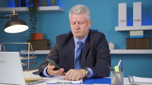 Adult Man Talking on the Phone at Desk