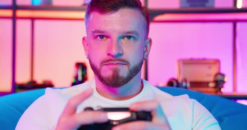 Focused Young Man Playing Video Game at Home