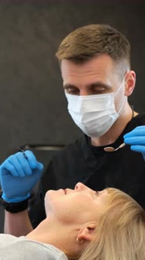 Dentist Examines Patient in Dental Chair