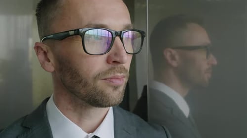 Man Wearing Glasses and Suit in Elevator