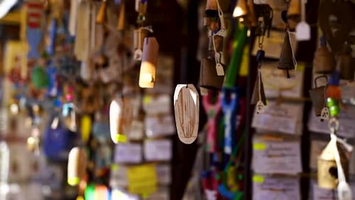 Several wind chimes on a market stall move in the wind.