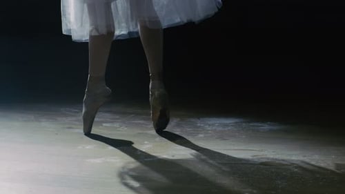 Close-up Shot of Ballerina's Legs. She's Dancing and Spinning on Her Pointe Ballet Shoes in the Spo