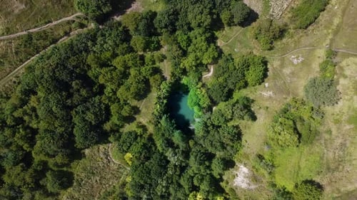 Aerial hight footage rotating around lake with turquoise water located in a mountain valley with
