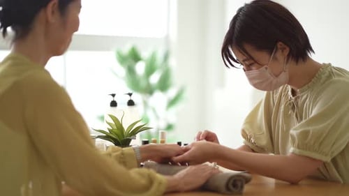 Beautician Applying Nail Polish in Beauty Salon