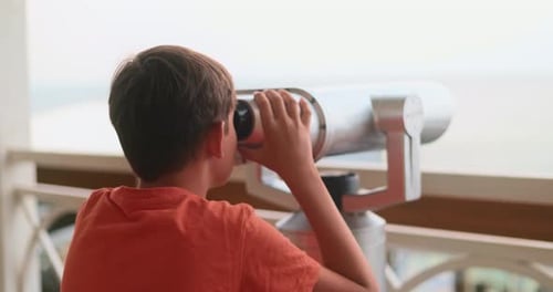 Boy Using Telescope Overlooking The Ocean