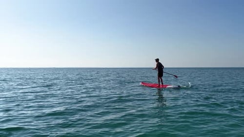 Man Paddle Boarding on Calm Ocean Water