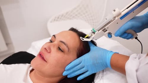 Woman Receives Hair Treatment with Automated Syringe Device