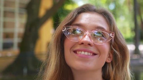 Smiling Blonde Woman with Laptop in Outdoor Cafe